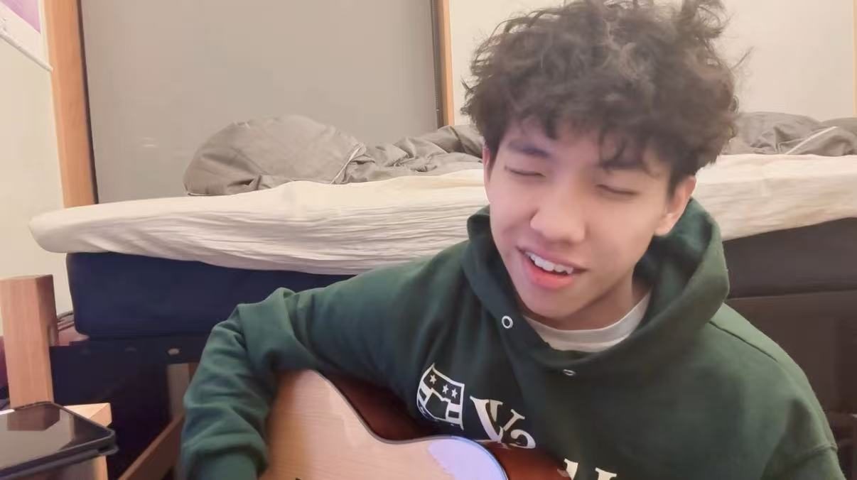 Jimmy singing while playing an acoustic guitar