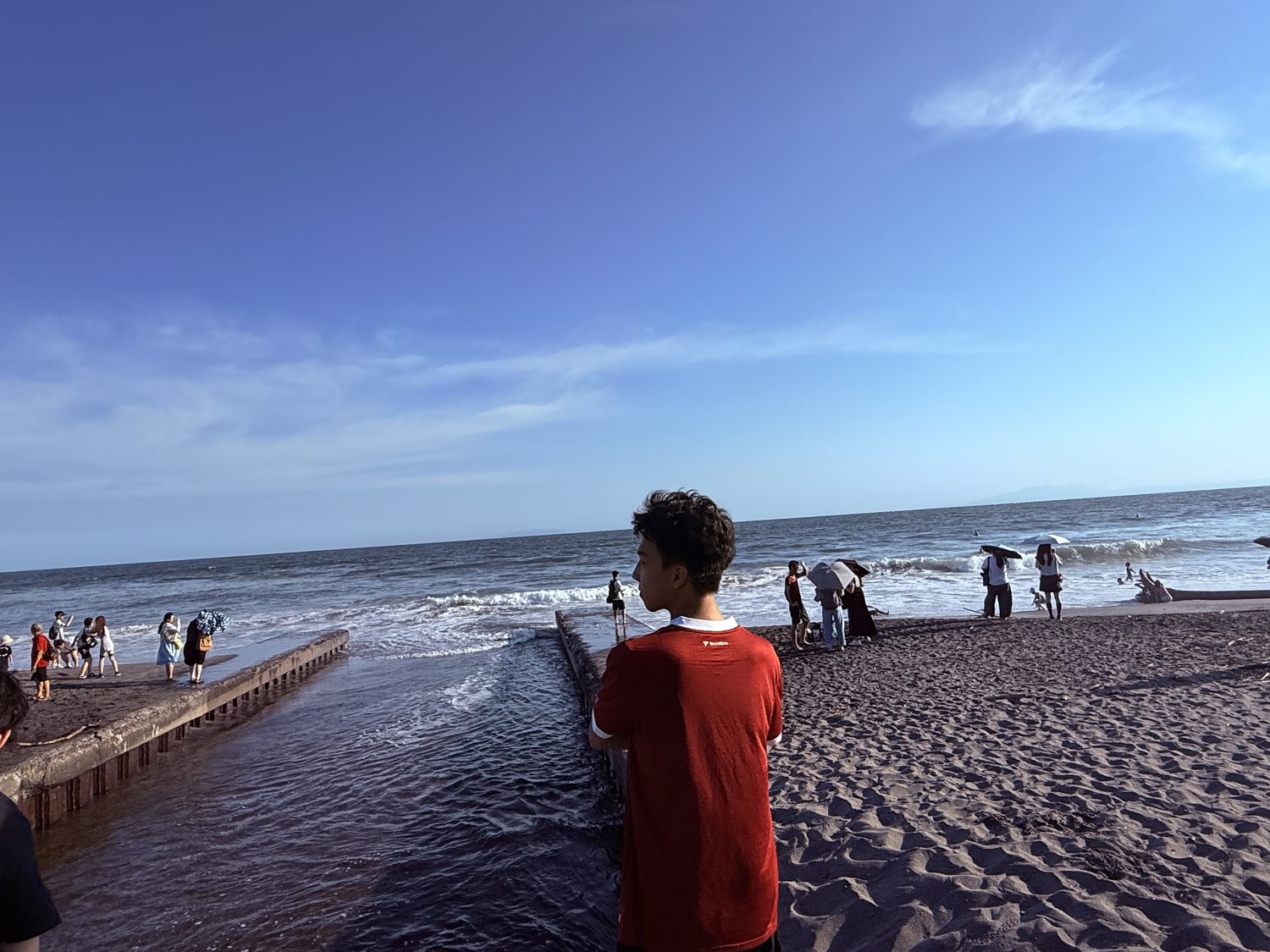 Jimmy standing on Shichirigahama beach in Japan, looking out at the sea
